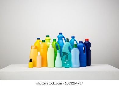 Still life of different types of plastic packaging on white and grey set arranged by colours