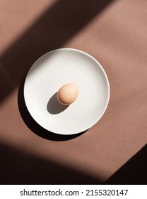 Still Life With An Egg On A Plate. Photos In Natural Colors. Minimal Food Concept. Dramatic Light And Shadows