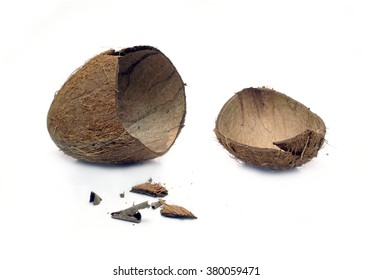 Still life with empty broken coconut shell and smithers isolated on white background. Horizontal close-up photo