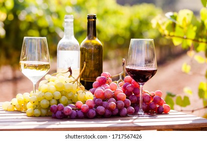 still life with glasses of red and white wine and grapes in field - Powered by Shutterstock