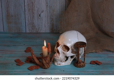 still life in Gothic Halloween style. runes, a skull, a candle, an hourglass with runic signs. The table of a witch, an alchemist, a magician.