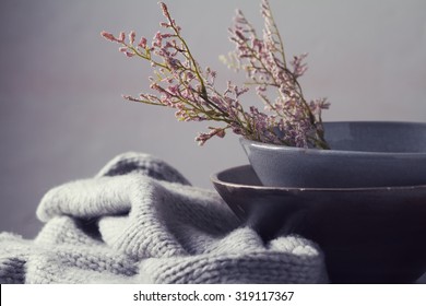 Still life gray vintage bowls with pink flowers and woolen scarf horizontal