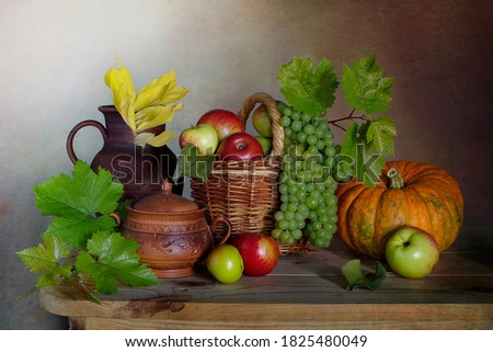 Still life with a harvest of apples,pumpkins and grapes on the table.Harvest festival.