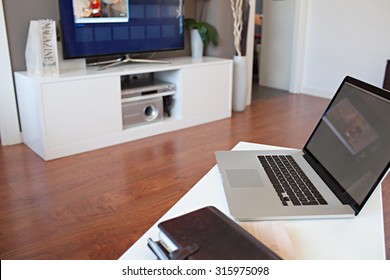 Still Life Of A Home Interior With Modern Technology And Entertainment. Living Room With Flat Screen TV And Open Laptop Computer With Blank Screen, Home Indoors. Technology Lifestyle Home, Interior.