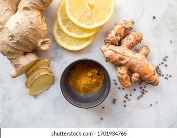 Still life of immune boosting food ingredients like Ginger and Turmeric roots, black pepper and lemon slices 