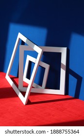 Still life installation: white square frames on blue and red background. Contrast abstract art design. Architectural project composition, 3d geometric interior modeling construction
