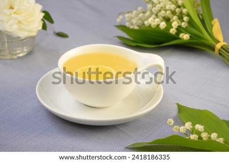 still life in light colors, a cup of tea and white flowers on the table