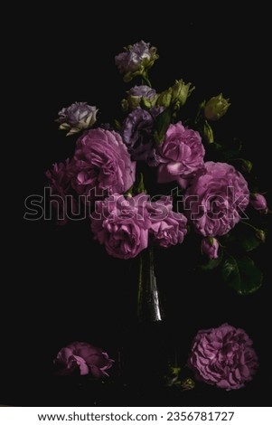 still life. luxury bouquet roses and lisianthus in a glass vase on a black background. Moody flowers. color bloom.