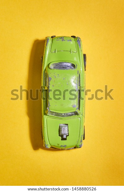 still\
life of model car from above a yellow\
background
