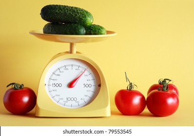Still Life With Modern Kitchen Scale And Vegetables On Yellow Background