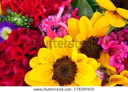 Still life over head view of a fresh, vivid and colorful bunch bouquet of a selection of different color and shape flowers and blossom in a floral market stall, together outdoors.