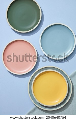 Still life of pastel colored ceramic dishes with linens napkins. Topview. 