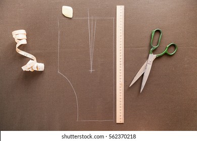 Still life photo of a suit pattern template with tape measure, chalk and scissors. Sewing and tailoring tools and accesories.   