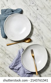 Still Life Photography Of A White Stoneware Bowls With Napery And Gold Cutlery On A Marble Background For Food Photography. Top View Mock Up.