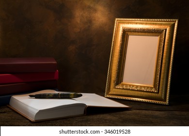 Still Life Of Picture Frame On Table With Diary Book.