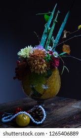 still life of pine cones, mushrooms, viburnum, wild apples and flowers on a wooden background