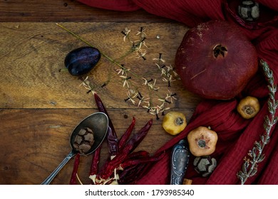 Still Life With Plums And Dried Herbs On Wooden Table. Top View Photo Of Large Group Of Objects. Autumn Mood Photo. 