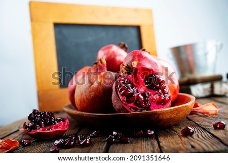 still life with red granates, pomegranates on wooden plate Imagine de stoc © 