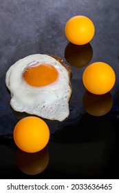Still life with a roasted scrambled eggs and orange balls on an abstract background