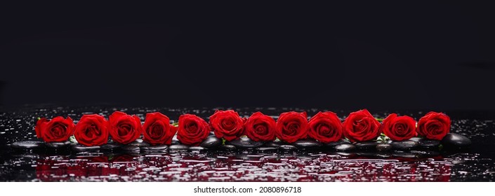 Still life of with 
Row of red rose and zen black stones wet background
