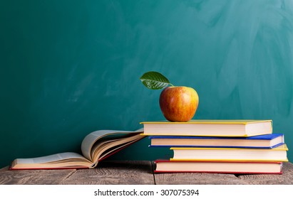 Still life with school books and apple against blackboard with "back to school" on background - Powered by Shutterstock