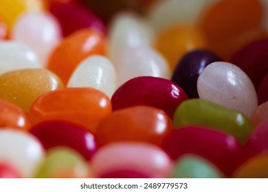 A still life shot of a pile of jelly beans on a table top, featuring two yellow ones in the foreground - Powered by Shutterstock