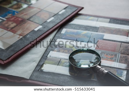 Still life with stamps in an album and magnifying glass. Ukrainian stamps