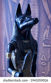 Still life of statue of mythology jackal anubis inpu anup. In the background are Egyptian motifs with hieroglyphs.