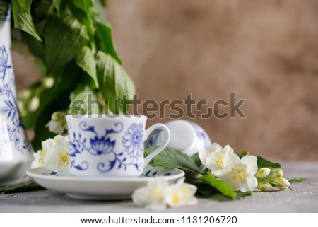 Still life with a tea set and jasmine flowers.