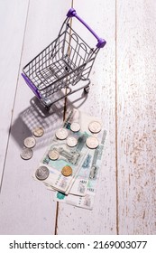 Still Life: There Is A Grocery Cart On The Table And Large Russian Money With Coins, The Concept Of The Rise In Price Of Goods