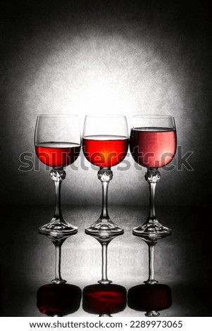 Still life with three glasses of red liquid