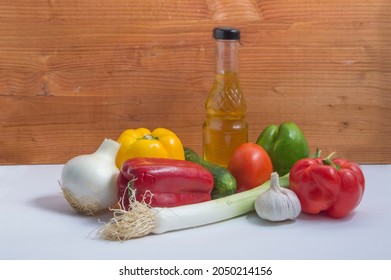 still life with  tomatoe, garlic,green pepper, red pepper,yellow, cucumber, olive oil glass botle, on wooden background - Shutterstock ID 2050214156
