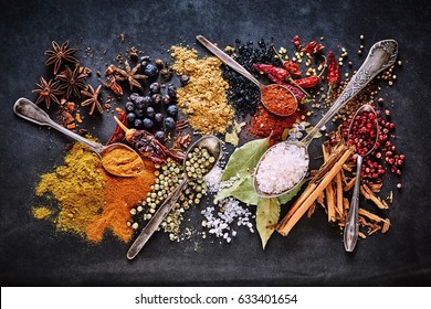 Still life of a variety of dried culinary spices for Asian and Oriental cuisine with curcuma, star anise, salt, cinnamon, peppercorns, acai, bay leaves, chili and cayenne pepper viewed from overhead - Powered by Shutterstock