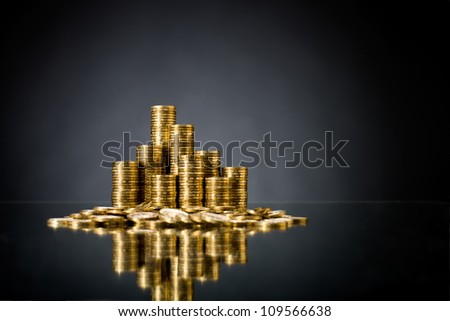 still life of very many rouleau gold  monetary or change coin, on dark blue background