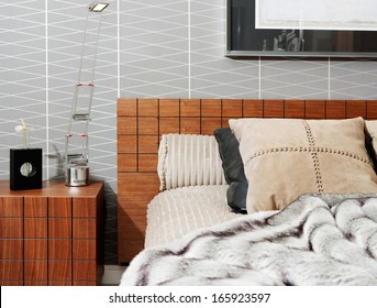 Still Life View Of A Stylish And Luxury Bedroom With A Wooden Bed Frame And A Picture On The Wall, Showing Graphic Masculine Wallpaper And A Fake Fur Blanket. Interior With No People.