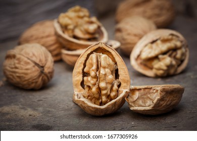 still life with Walnut kernels and whole walnuts on rustic old wooden table.