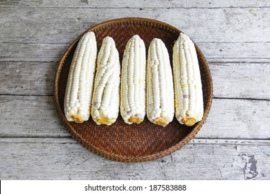 still life with white corn in the threshing basket on wooden table.Flat lay 