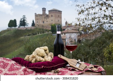Still Life of White Truffles from Piedmont, truffles cuts and bottle with glass of red wine, with a view of the vineyards and the castle of Grinzane Cavour