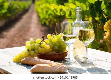 Still life with white wine, grapes and fresh bread on table in vineyards .. - Powered by Shutterstock