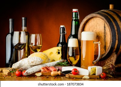 still life with wine, beer, traditional food, cheese and sausages