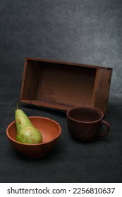 Still life with a wooden box and a pear in a plate - Shutterstock ID 2256810637