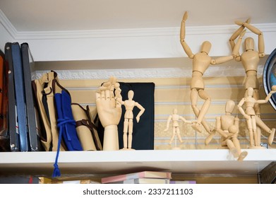 Still life. Wooden drawing mannequin dummy to learn how to draw human body in position of movement, displayed on shelf in creative department of school stationery store. Creativity. Hobby. Fine art. - Powered by Shutterstock