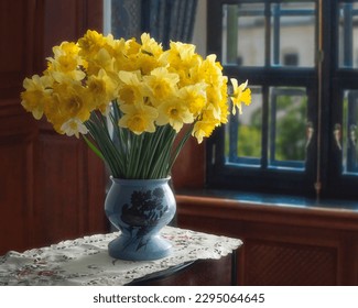 Still life with yellow daffodils in vase on table - Shutterstock ID 2295064645