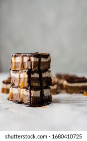 Stilllife Of A Stack Of Three Vegan No-bake Chocolate Date And Coconut Healthy Bites With Peanutbutter And Syrup