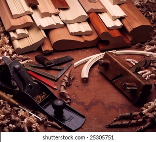 Still-life of wood moldings, wood shavings, and hand-tools. Block planes, carpenter's square, pencil.