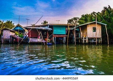 Stilt houses built above river Mae Klong in Amphawa, rural Thailand. Beautiful countryside landscape at sunset. - Powered by Shutterstock