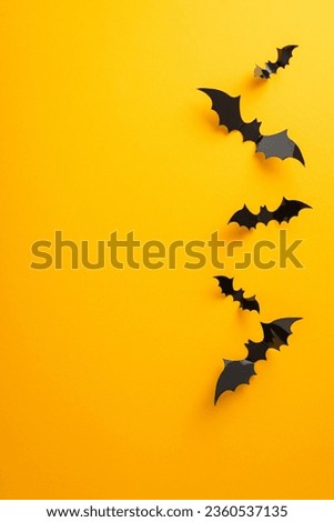 Stir excitement for your Halloween party using this concept. Visualize vertical top view setup with creepy bats on a yellow backdrop, open for your content