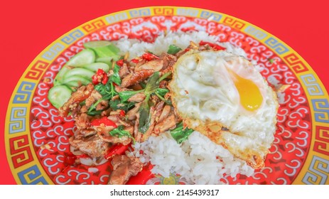 Stir fried duck with chilli and basil, Thai spicy food eat with sunny side up fried egg and cucumber on the side. Call pad kra pao in Thai, famous menu.