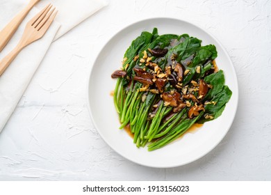 stir fried kale (Chinese Broccoli) in oyster sauce with Shitake Mushrooms and fried garlic.Top view.