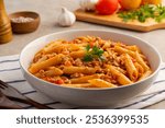 Stir fried penne macaroni with tomatoes sauce and mince pork on a plate